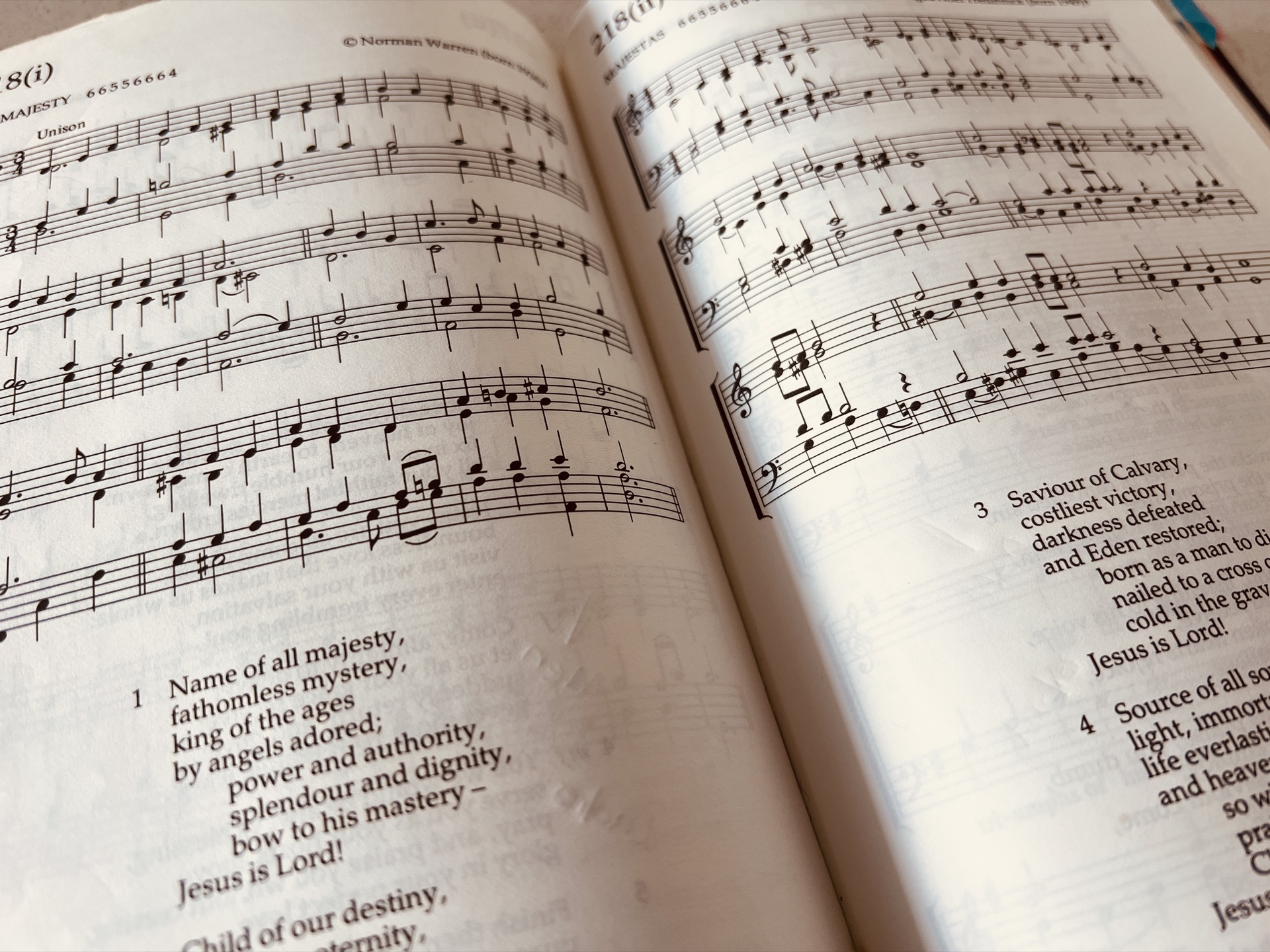 Hymn book open on a piano music stand
