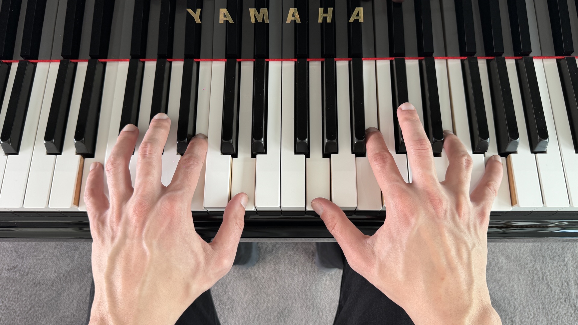 Teléfono apoyado en el atril de un piano vertical mientras un alumno toca